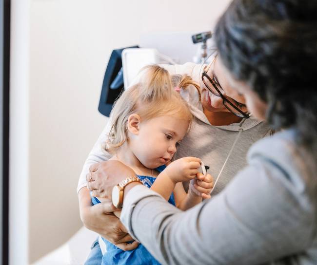 Madre reconforta a su hija en una cita médica