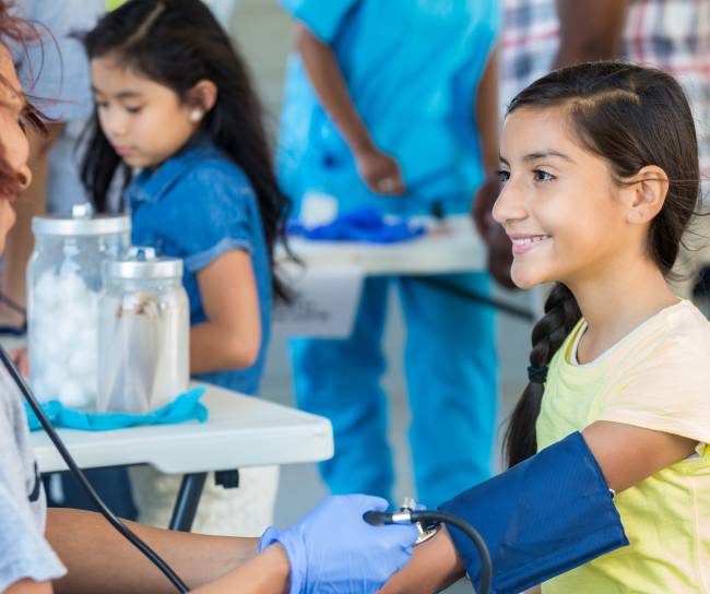 Niña recibiendo atención de una doctora.